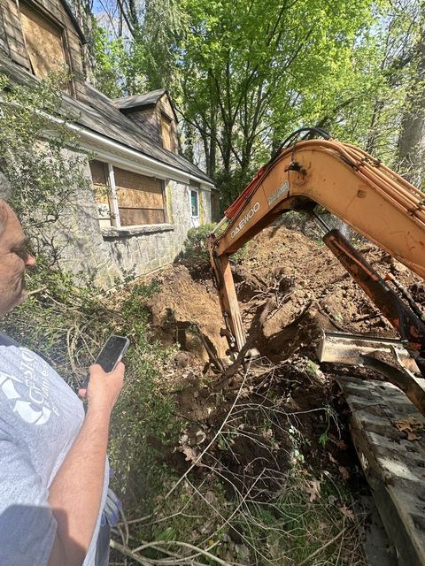 Excavator digging alongside the structure during tank exposure